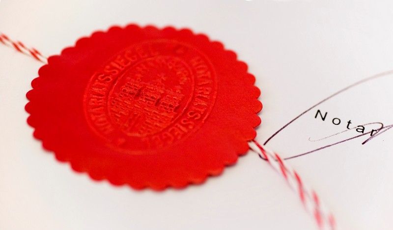 Rotes Notarsiegel auf beglaubigter Urkunde mit Unterschrift von einem Notar in Delmenhorst.